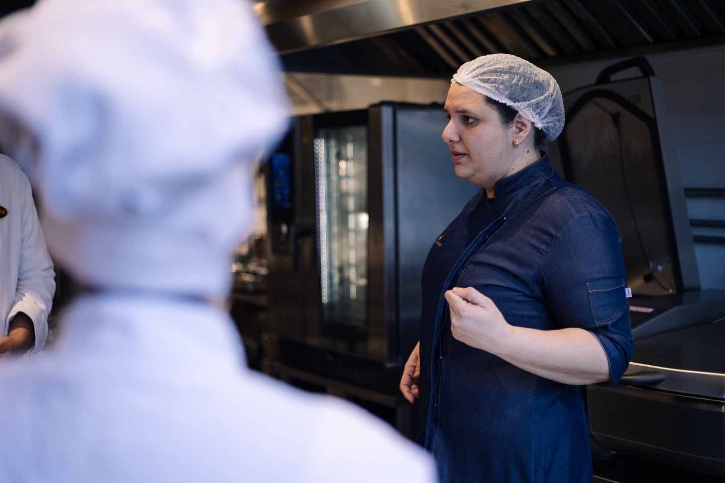 Nattalia orienta a equipe em uma cozinha profissional